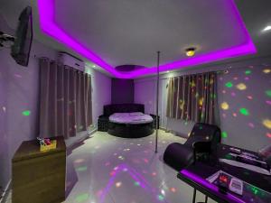 塔瓜汀加Motel Gold的一间设有一张床和紫色天花板的客房