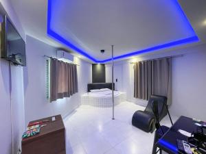 塔瓜汀加Motel Gold的一间设有床铺和蓝色天花板的客房