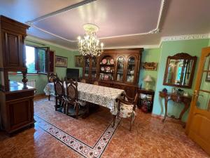 拉科鲁尼亚Impresionante casa con parcela en la naturaleza的一间带桌椅和吊灯的用餐室