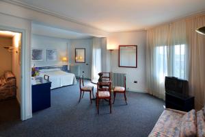 巴尔巴斯特罗桑乔莱米雷斯国王酒店的酒店客房带一张床、一张桌子和椅子
