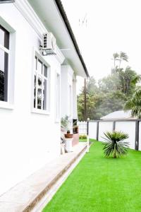 龙运Tanjung Jara Cottage - with indoor pool的白色的房子,有绿草的院子