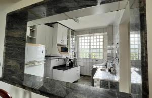 圣维森特岛Apartamento no topo da Ilha Porchat的厨房配有白色家电和大镜子