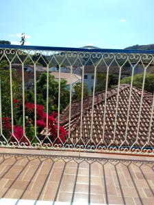 康赛瓦托利亚Pousada das Flores的金属围栏,有粉红色的花朵