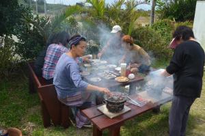 本部伊萨旅馆的一群人站在桌子旁准备食物