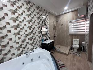 阿克拉T-Roys Apartments的带浴缸和卫生间的浴室。