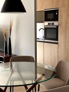 蒙得维的亚Apartamento deluxe en Pocitos_Life Veintiseis Apartments的客厅配有玻璃桌和椅子