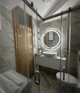 亚霍里纳Gondola Apartments的一间带水槽、卫生间和镜子的浴室