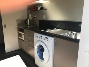 纳尔逊Apartment on Stansell的厨房配有洗衣机和水槽