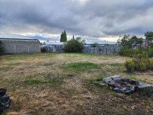 纳塔列斯港Casa en Puerto Natales的草地上带火坑的后院