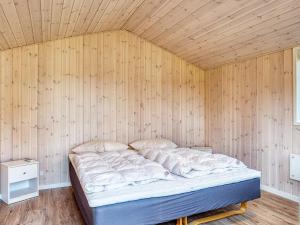 莱斯Holiday home Læsø LIII的木墙客房的一张床位