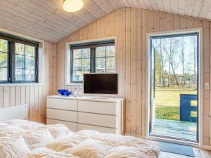 莱斯Holiday home Læsø LIII的一间卧室配有一张床,梳妆台上配有电视