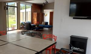 ChasquiEl Chasqui Guest House的客厅配有桌椅和电视。