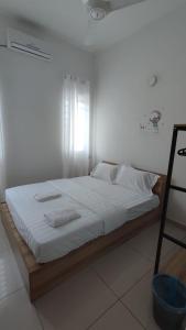 务边Gopeng Serumah Holiday House的一张带白色床单和枕头的床