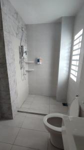 务边Gopeng Serumah Holiday House的带淋浴和卫生间的白色浴室