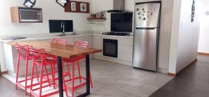 ChasquiEl Chasqui Guest House的厨房配有木桌和冰箱。
