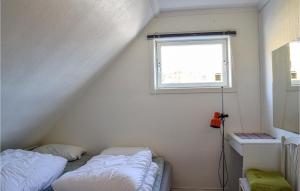 UtåkerLovely Home In Utker With Wifi的小型客房 - 带2张床和窗户