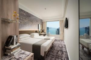 香港香港都会海逸酒店的酒店客房设有两张床和大窗户。