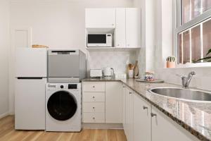 悉尼Beach-side North Bondi的白色的厨房配有洗衣机和水槽