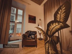 巴勒莫CITRUS LUXURY APARTMENT - holiday apartment with up to 3 bedrooms in palermo center的一间带椅子和植物的客厅