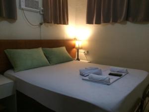杜马格特CrisFil's Lodge Incorporated的一间卧室配有一张床,上面有两条毛巾