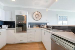 珀斯Suite 305 Sandcastles 3 Bedroom Deluxe Apartment的厨房配有白色橱柜和不锈钢用具