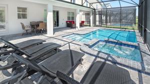 基西米Luxury 9BR Villa @ Storey Lake Resort Near Disney的一个带椅子的游泳池以及一座房子