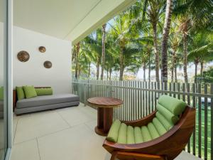 塞米亚克巴厘岛W度假村 - 水明漾的阳台配有桌椅和棕榈树。