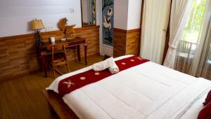 珀尼达岛La Nusa Penida Homestay的一间卧室配有一张床、一张桌子和一张桌子