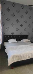 戈勒克布尔SPOT ON Hotel Paradise Inn的一间卧室配有一张黑白墙床