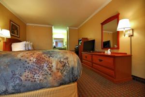 基林Americas Best Value Inn Killeen Ft Hood的酒店客房设有一张床和一个带镜子的梳妆台