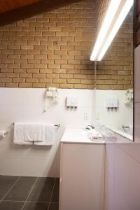 斯托尔Goldfields Motel的一间带白色水槽和砖墙的浴室