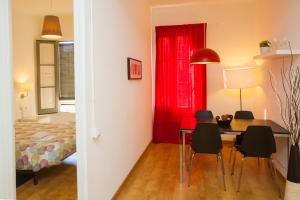 巴塞罗那高迪圣家堂酒店的一间卧室配有红色窗帘和桌椅