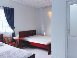 Ấp Rạch MẹoNhà nghỉ Thành Lợi的一间卧室配有一张床、一张桌子和一个窗户。