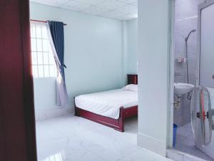 Ấp Rạch MẹoNhà nghỉ Thành Lợi的一间卧室配有一张床、一个水槽和淋浴