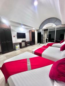 卡利Hotel Ingenio Reina Isabel的一间卧室设有四张床和一台平面电视。