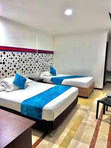 卡利Hotel Ingenio Reina Isabel的酒店客房 - 带两张带蓝色枕头的床