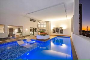 巴迪纳Upmarket Comfortable Large 2 Bed 2 Bath, OCEAN VIEWS, 250m to BUDDINA BEACH!的一座大型游泳池,位于带房子的房间里