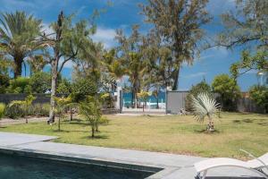 圣吉尔莱班Ô 3 CAP - Magnifique Villa 8 personnes avec piscine, face à la plage de Boucan-Canot的享有树木公园和游泳池的景色