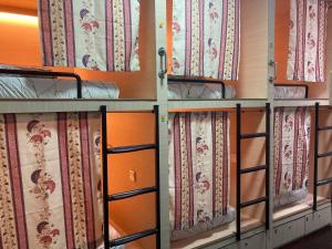 马六甲Stop @Melaka Guesthouse的窗帘间的一排双层床