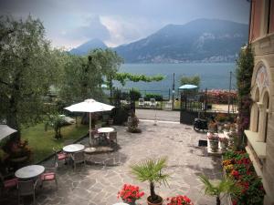 布雷佐内加尔达Villa Torre - Atmosfera Romantica的一个带桌椅的庭院,享有水景