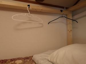 美祢Guest House Himawari Dormitory Room - Vacation STAY 32624的卧室配有一张床和墙上的衣架