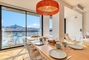 马赛La Sentinella - Appt au dessus du Vieux Port的一间带桌子和大窗户的用餐室