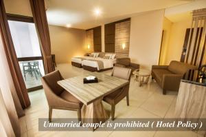 雅加达Hotel Gren Alia Jakarta的酒店客房带一张床、一张桌子和椅子