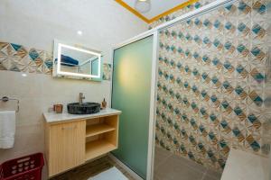马埃岛Paradise Breeze Apartment的带淋浴、水槽和镜子的浴室