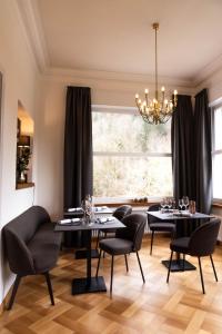巴特利本采尔OSCARS Hotel 1415的一间用餐室,配有黑色的桌椅和窗户