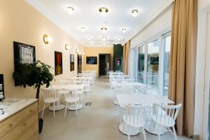 苏博蒂察Artist hotel的一间设有白色桌子和白色椅子的餐厅