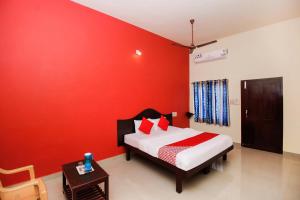 根尼亚古马里Hotel Aljemin的红色的墙卧室配有一张床和一张桌子