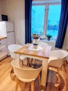 奥勒松Light home apartment Alesund with free parking的厨房配有一张桌子,上面放着花瓶