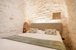 阿尔贝罗贝洛特鲁利迪齐亚维多利亚住宿加早餐旅馆的卧室配有一张石墙床