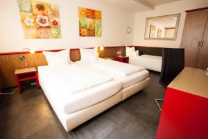 科隆Trip Inn Hotel Ariane的酒店客房设有两张床和一张红色的桌子。